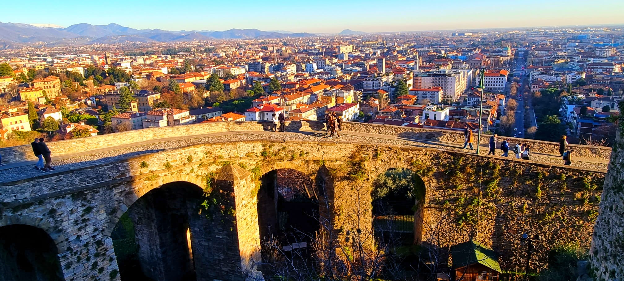 Elegant Italian bedroom with traditional wooden beams and warm lighting in Bergamo